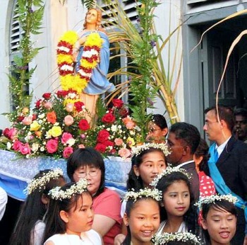 Image: The statue of Our Lady of the Rosary being carried in procession with sugar cane stalks in the background at the Assumption Chapel in Malacca recently