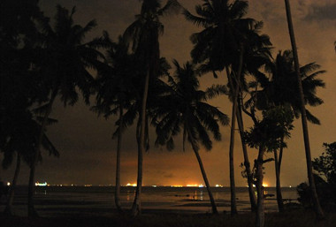 Image: Lights from the fleet of ships illuminate the night-time horizon.