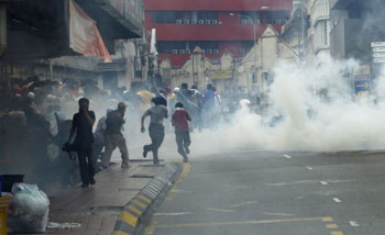 Afbeelding: Demonstranten rennen weg voor traangas in de straten van Kuala Lumpur